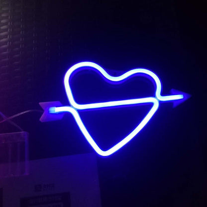 Una flecha a través de las luces de neón de látex en forma de corazón